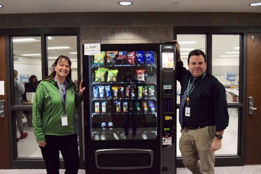 Principal Andy Beaton (right) recently signed a contract with Midwest Vending to provide a small discretionary income for EHS. Pam Berling (left) poses with a new machine.