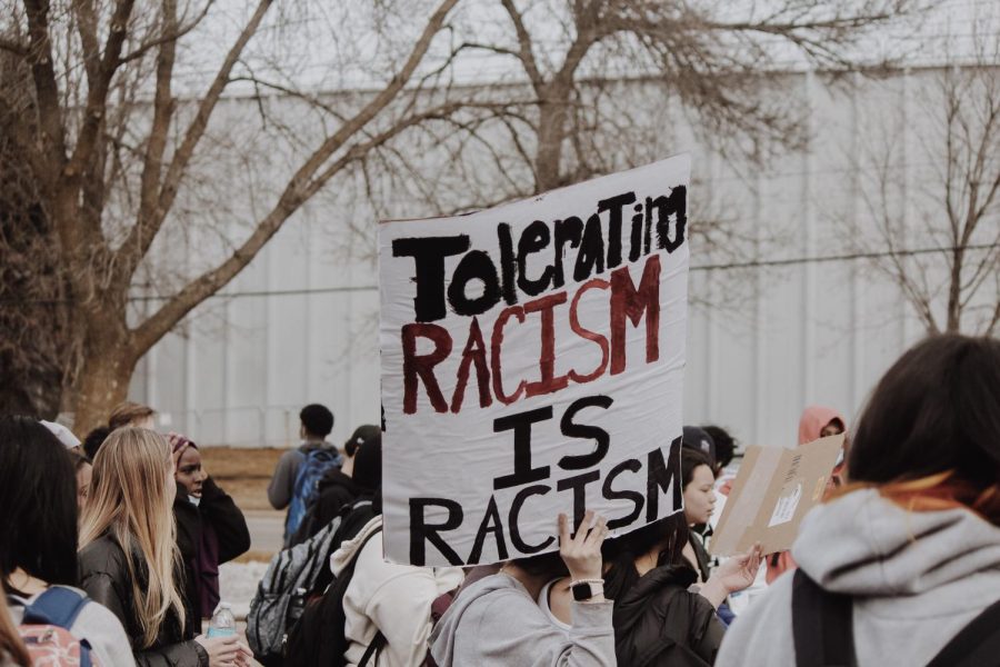 Amidst the chatter, students retrieved signs—a few read “Tolerating Racism is Racism” and “Racism is the Biggest Pandemic”—and prepared themselves for the trek to Lewis Park. 