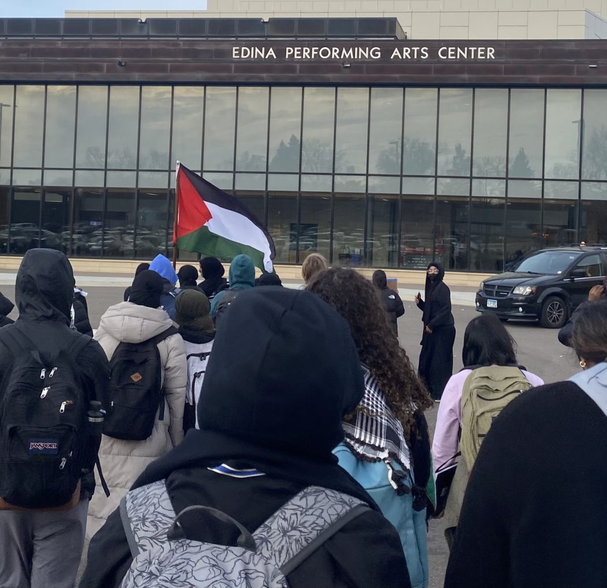 Students walk in front of the Edina Performing Arts Center during the walkout for Palestine.