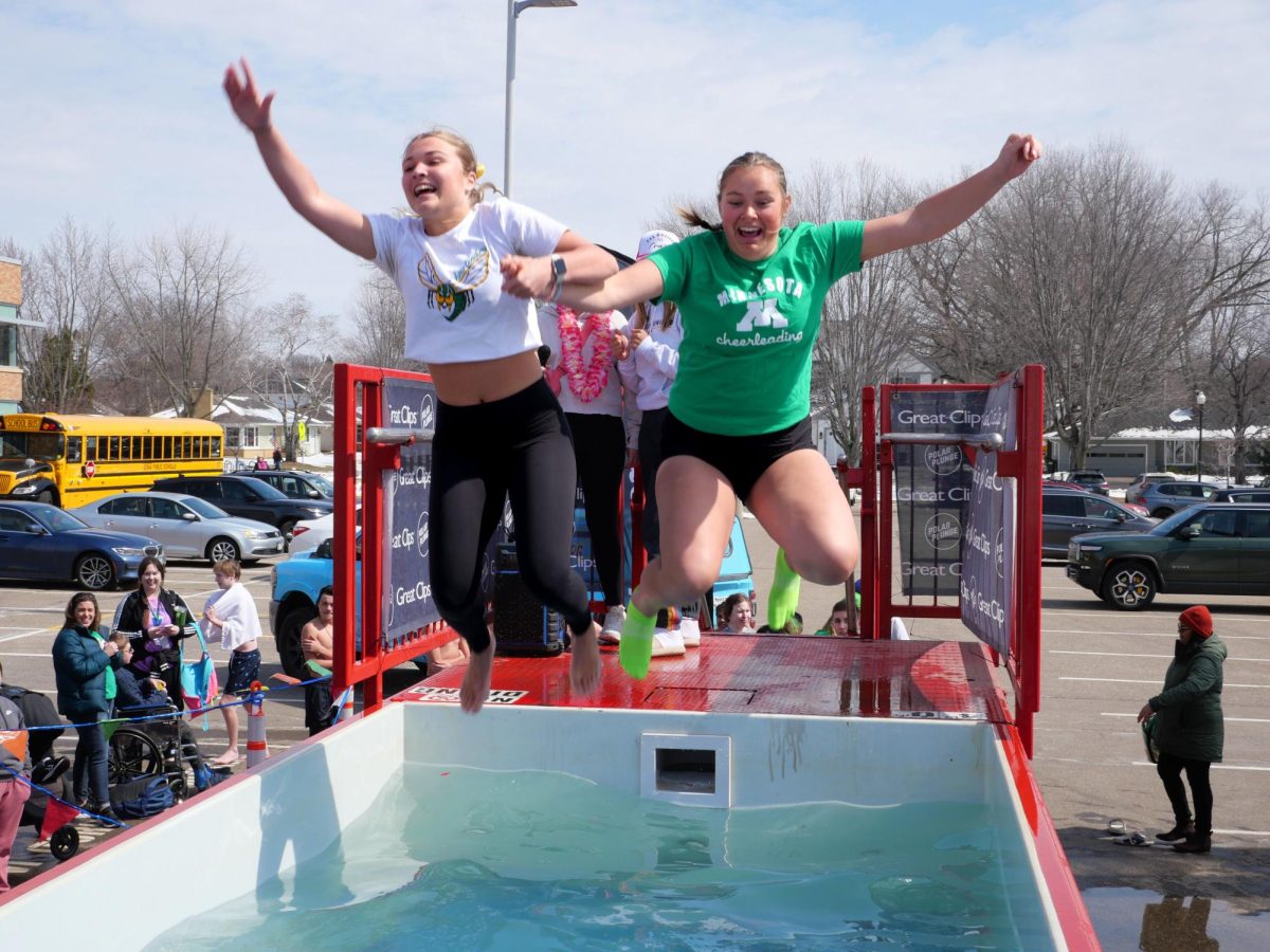 Freshman+Molly+Nelson+%28left%29+and+senior+Krisalyn+Cook+%28right%29+take+the+ice-cold+plunge+together.+With+the+roaring+music+and+excitement+of+the+crowd%2C+EHS+students+leaped+with+smiles+on+their+faces.