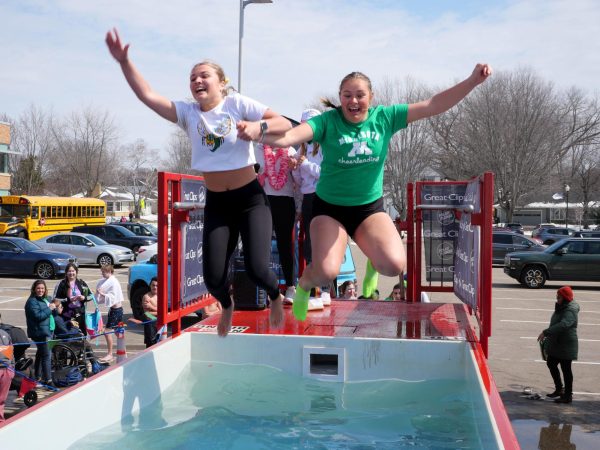 Freshman Molly Nelson (left) and senior Krisalyn Cook (right) take the ice-cold plunge together. With the roaring music and excitement of the crowd, EHS students leaped with smiles on their faces.