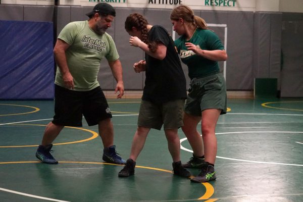 Coach Joshua Burhans coaches two wrestlers during the Girls Wrestling Clinic on Tuesday May 7th, 2024.