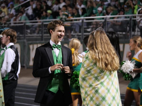 Senior Homecoming court member Wilson Schaefer and Homecoming Queen Rylie Nelson chat on the sideline during the Homecoming football game.