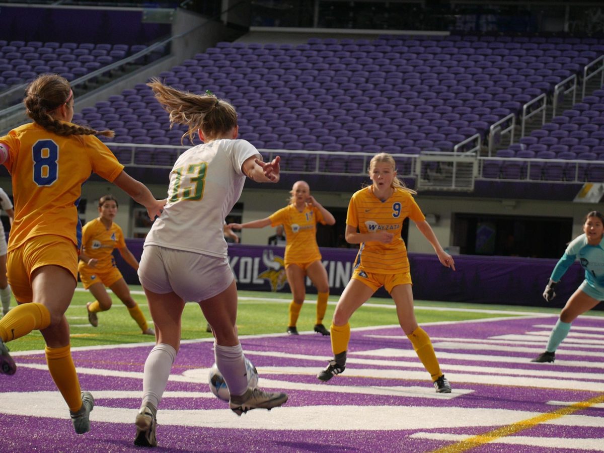 Senior defender Anna Conner kicks the ball past Wayzata defenders.