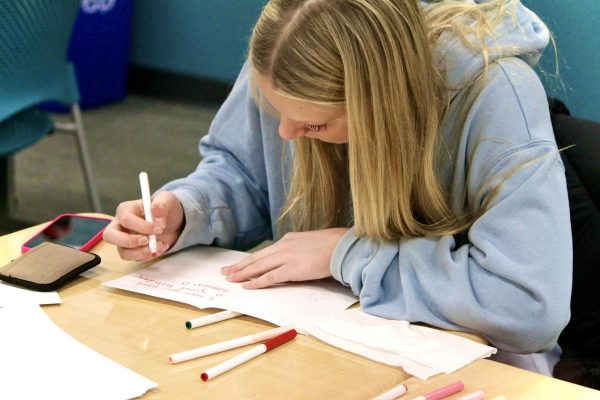 Junior Anja Nymo writes holiday cards for local nursing homes.