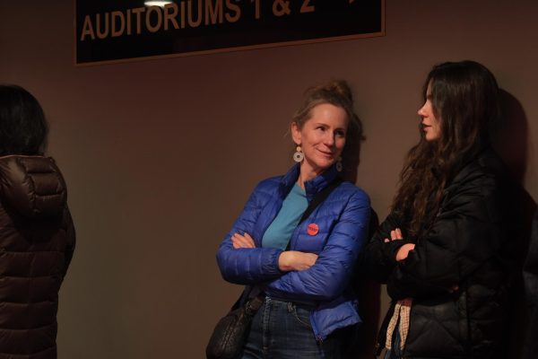 Film goers wait in line for their auditorium to open chatting about the night ahead.